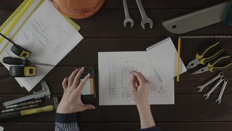 Top down view. A guy is checking information in the schematics Stock Footage 80020828