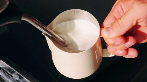 Top Down View Of Hand Holding Milk Pitcher While Steam Wand Froths Milk Creating Stock Footage 331365445