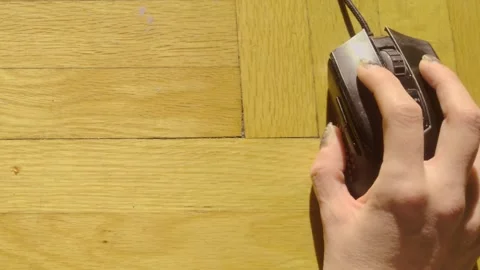 Top Down View of Hand Navigating Black Mouse on Natural Wood Floor Stock Footage 327523891