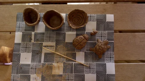 Top-Down View of Handmade Clay Bowls and Animal Figures Stock Footage 347909918
