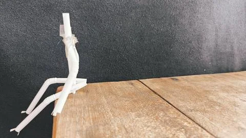 Top down view of a handmade straw and cardboard figure resting on a scratch.. Stock Photos