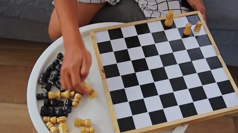 Top-down view of hands arranging chess pieces on board while relaxing on sofa Stock-Footage 346030349