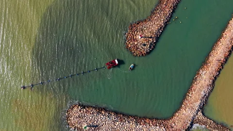 Top down view of harbor entrance with dredging ship Stock Footage 330864457