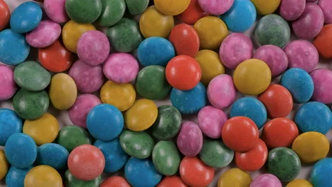 Top down view. Heap of multi colored dragees. Glazed bonbon candies. Video stock 296517143