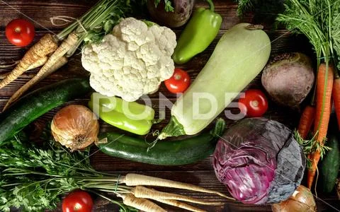 Top down view, heap of various vegetables on dark wooden board Stock Photos
