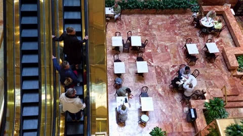 Top-down view from highest floor showing elevators moving and guests seated in Stock Footage 337744058