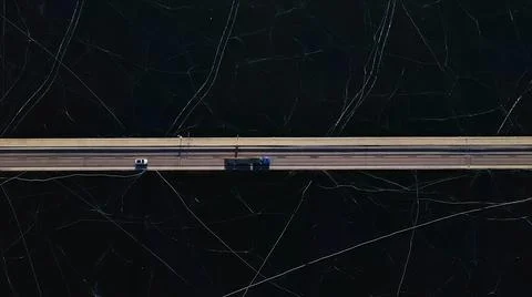 Top down view of a highway bridge spanning over a frozen lake. Stock Photos