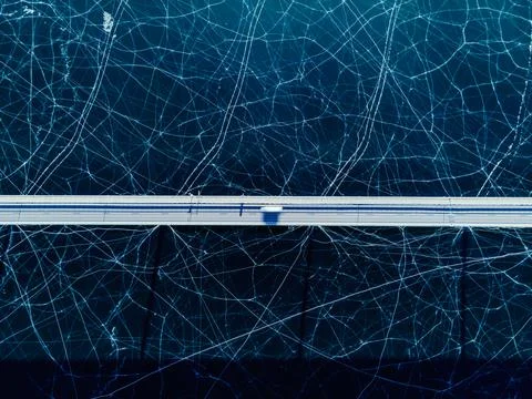Top down view of a highway bridge spanning over a frozen lake. Stock Photos