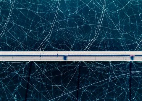 Top down view of a highway bridge spanning over a frozen lake. Stock Photos