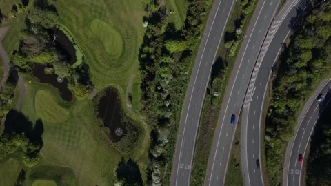 Top Down View of Highway Traffic Flowing Beside a Lush Golf Course Stockbeeldmateriaal 334168197