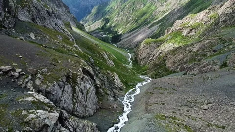 Top down view of hikers resting on rocky river bank by rushing mountain stream Video stock 335076153