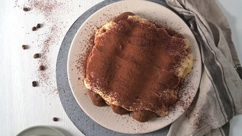 Top down view of homemade tiramisu cake dusted with cocoa powder on a rustic tab Stock Footage 340143853