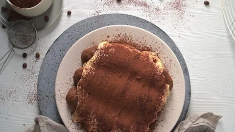Top down view of homemade tiramisu cake dusted with cocoa powder on a rustic tab Stock Footage 340143855