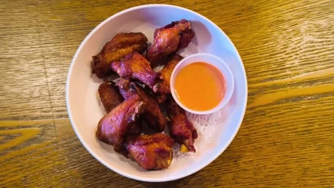 Top down view of hot freshly fried grilled cooked chicken wings with creamy sauc Video stock 318260882