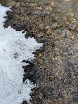 Top Down View of Ice Formations and Snow on a Flowing Rocky Creek Bed 스톡 사진