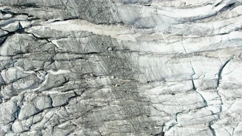 Top down view of ice glacier in the mountains with deep black crevasses Stock Footage 164152072