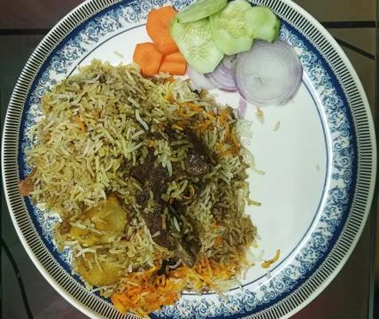 Top-down view of Indian mutton biryani with potato and fresh salad Stock Photos