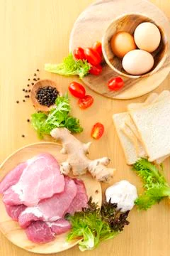 Top down view ingredients such as pork, eggs, tomato, ginger on wooden table. Stock Photos
