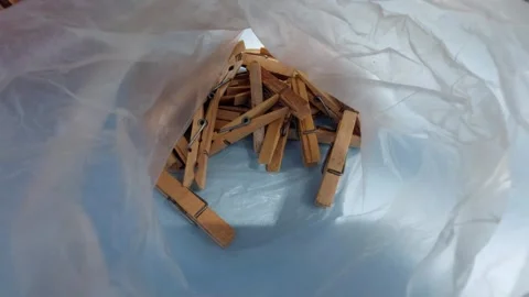 Top down view inside a plastic bag filled with vintage wooden clothespins Stock Footage 336487751