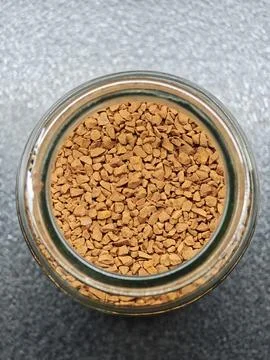 Top-Down View of Instant Coffee Granules in a Glass Jar Фото