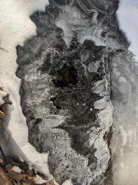 Top Down View of Intricate Ice Formations Over Dark Winter Water 스톡 사진