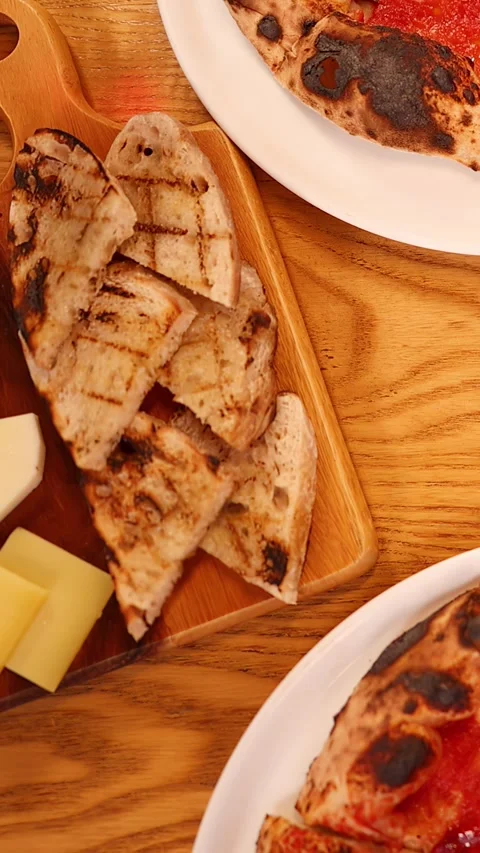 Top Down View of Italian Pizza and Cheese Board on Wooden Table Stock Footage 337925838