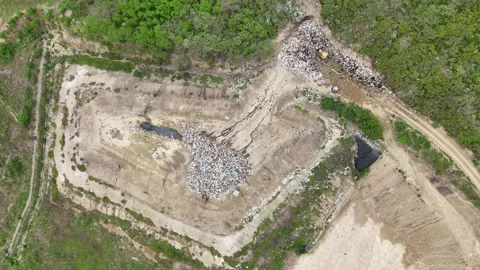 Top-down view of landfill showing a bulldozer and leachate pools Stock Footage 340410169