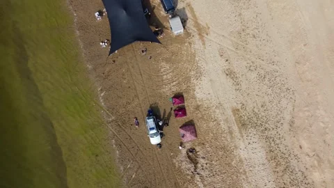 Top down view of large camping tent and off-road cars on sandy river beach Vidéo 334624929