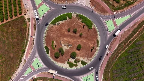 Top-down view of a large circular roundabout with landscaped island, multiple 库存影片 335000695