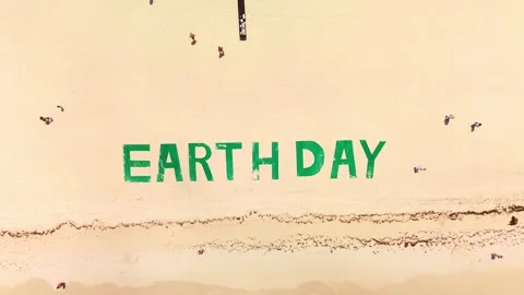 Top down view of large green title on tropical beach says EARTH DAY. People Video stock 273869530
