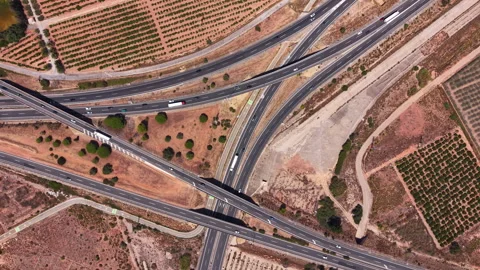 Top-down view of a large highway interchange surrounded by dry terrain and 動画素材 345103332
