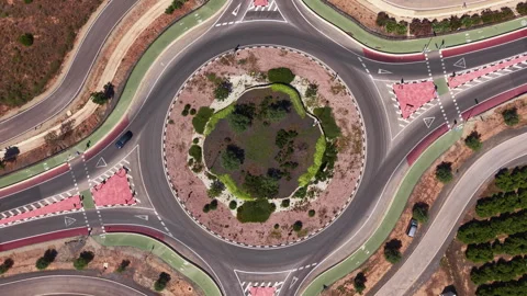 Top-down view of a large road roundabout with a circular green landscaped Stock Footage 341466356