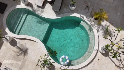 Top down view of a lifebuoy floating in a turquoise swimming pool at a luxury Stock Footage 321544822