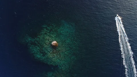 Top down view from a lighthouse in the middle of the sea and a driving boat Stock Footage 104283730