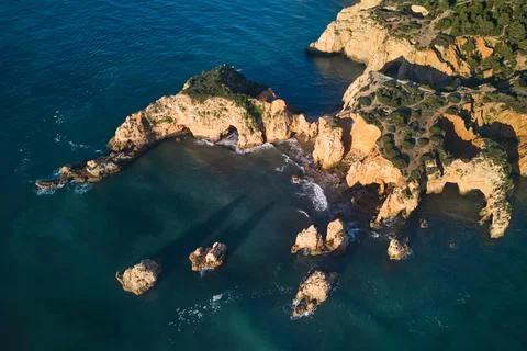Top-down view of the limestone cliffs with grottoes washed by the ocean Stock Photos