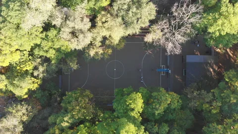 Top down view of local kids playing basketball in the park on a small basketball Stock Footage 155692150