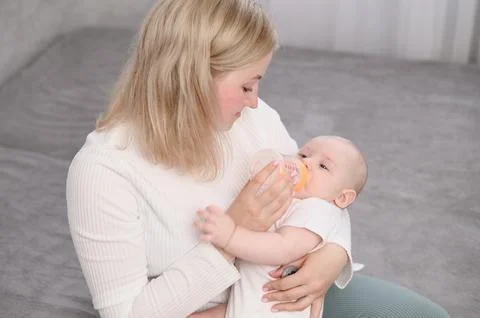 Top-down view of loving mother and baby. Mom cares for newborn baby, feeding him Stock Photos