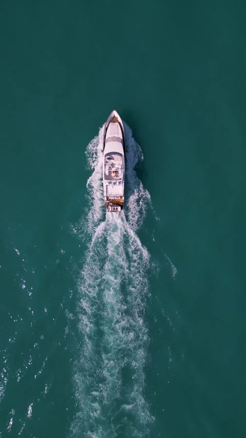 Top Down View of Luxury Motor Yacht Cruising in Deep Turquoise Ocean Vídeo Stock 340392493