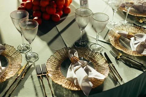 Top-down view of luxury table setting with gold charger plates and napkin rings Stock Photos