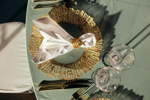 Top-down view of luxury table setting with gold charger plates and napkin rings Stock Photos