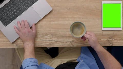 Top down view of male unrecognizable office worker at table behind laptop with Stock Footage 248687201