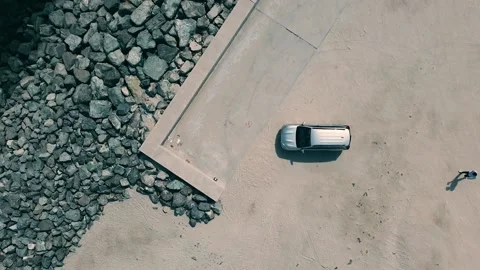 Top down view of a man getting into his car in a remote sandy area. Stock Footage 135406091