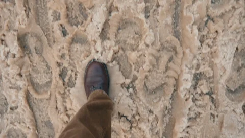 Top-down view man wearing leather boots walking through slushy snow city street Stock Footage 326826654