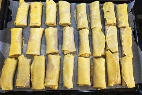 Top-Down View of Many Meat-Filled Crepe Rolls Arranged on a Baking Tray Stock Photos