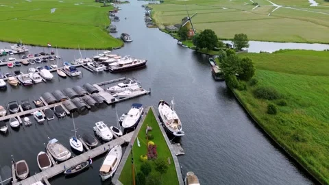 A top-down view of a marina with multiple boats docked along wooden piers Stock Footage 312665308