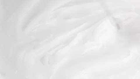 Top-down view of metal spatula smearing white cream. Rotating texture of fa.. Stock Footage 317317011
