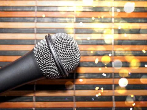 Top-Down View of a Microphone Head on a Striped Yellow and Black Bamboo Mat Stock Photos