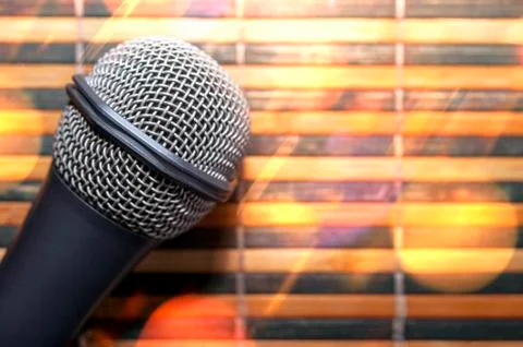 Top-Down View of a Microphone Head on a Striped Yellow and Black Bamboo Mat Stock Photos