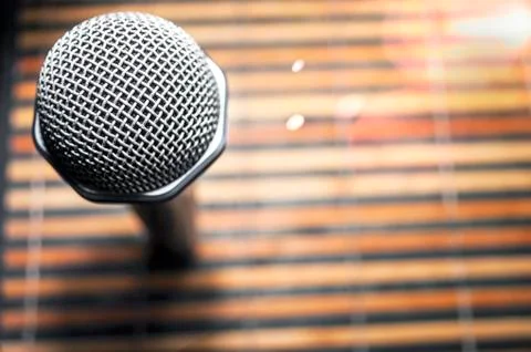 Top-Down View of a Microphone Head on a Striped Yellow and Black Bamboo Mat Stock Photos