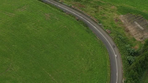 Top Down View of Motorcycle on Curving Road Through Pastures Stock Footage 347125580